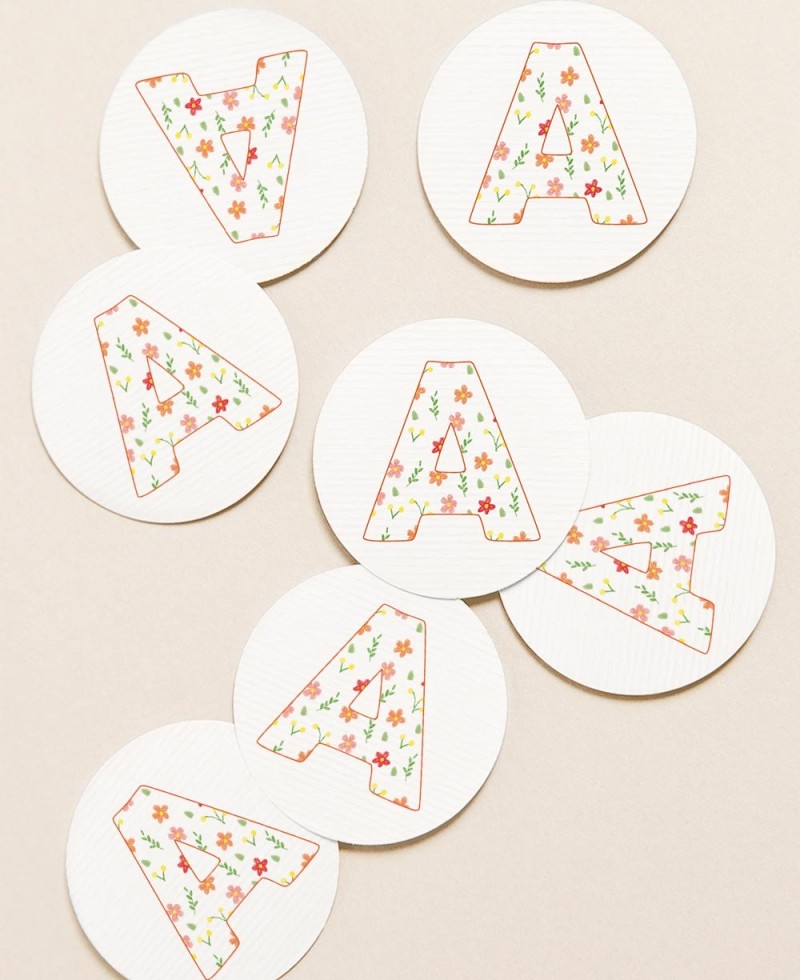 Étiquettes circulaires pour cadeaux de baptême initiales fleurs